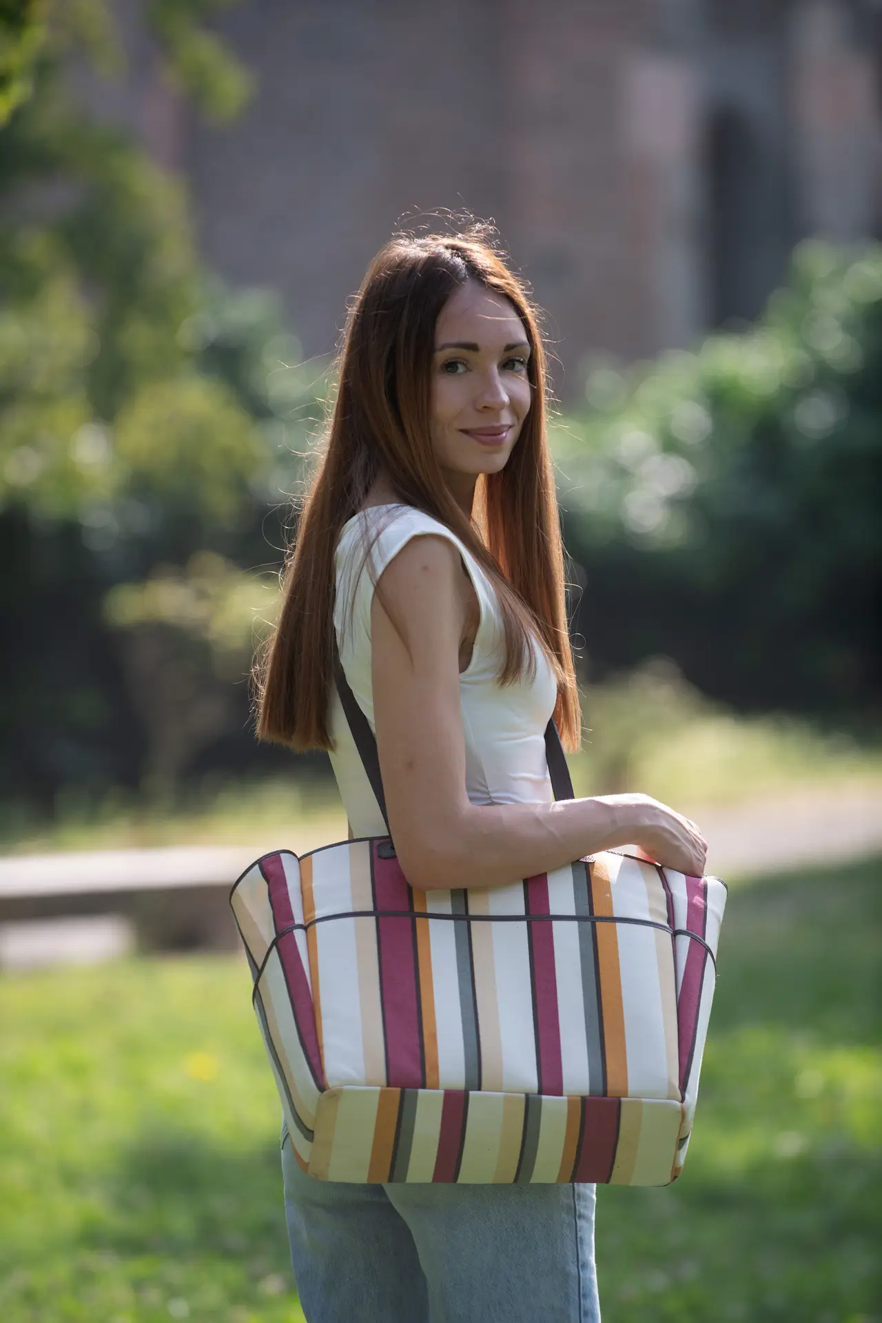 Modella in un parco con borsa Lemanì, stile casual ed elegante