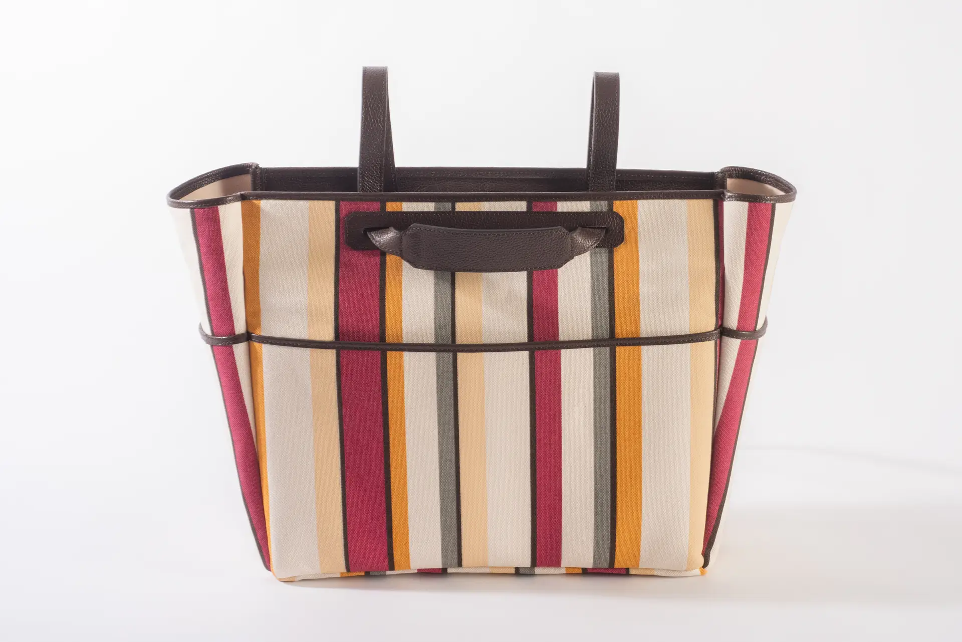 Borsa tote Liber_TO di Lemanì con fantasia multiriga in tonalità di rosso, giallo, bianco e grigio, con finiture e manici in pelle marrone scuro, ripresa frontalmente su sfondo bianco. Questa vivace e stilosa borsa a mano Liber_TO del brand Lemanì è perfetta per aggiungere un tocco di colore al tuo look.