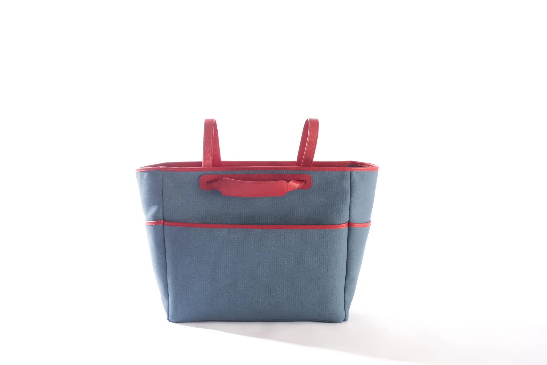 Borsa tote Liber_TO di Lemanì in cotone blu avio con dettagli e manici superiori in pelle rossa, ripresa frontalmente su sfondo bianco. Questa elegante e vivace borsa Liber_TO del brand Lemanì è l'accessorio perfetto per aggiungere un tocco di colore al tuo stile.