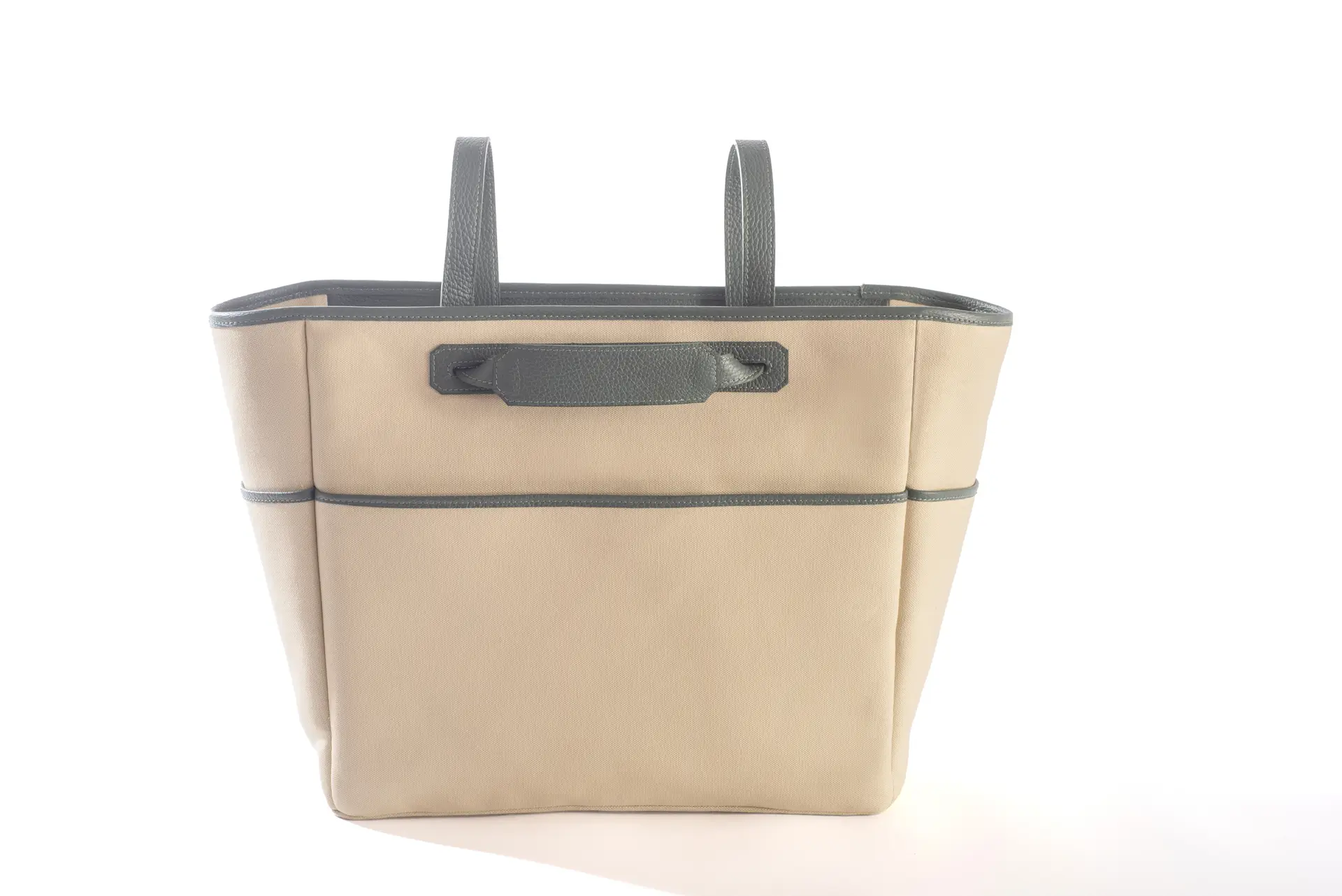 Borsa tote Liber_TO di Lemanì con esterno in cotone beige e dettagli in pelle verde salvia, ripresa frontalmente su sfondo bianco. Questa versatile e capiente borsa Liber_TO del brand Lemanì è perfetta per ogni occasione.